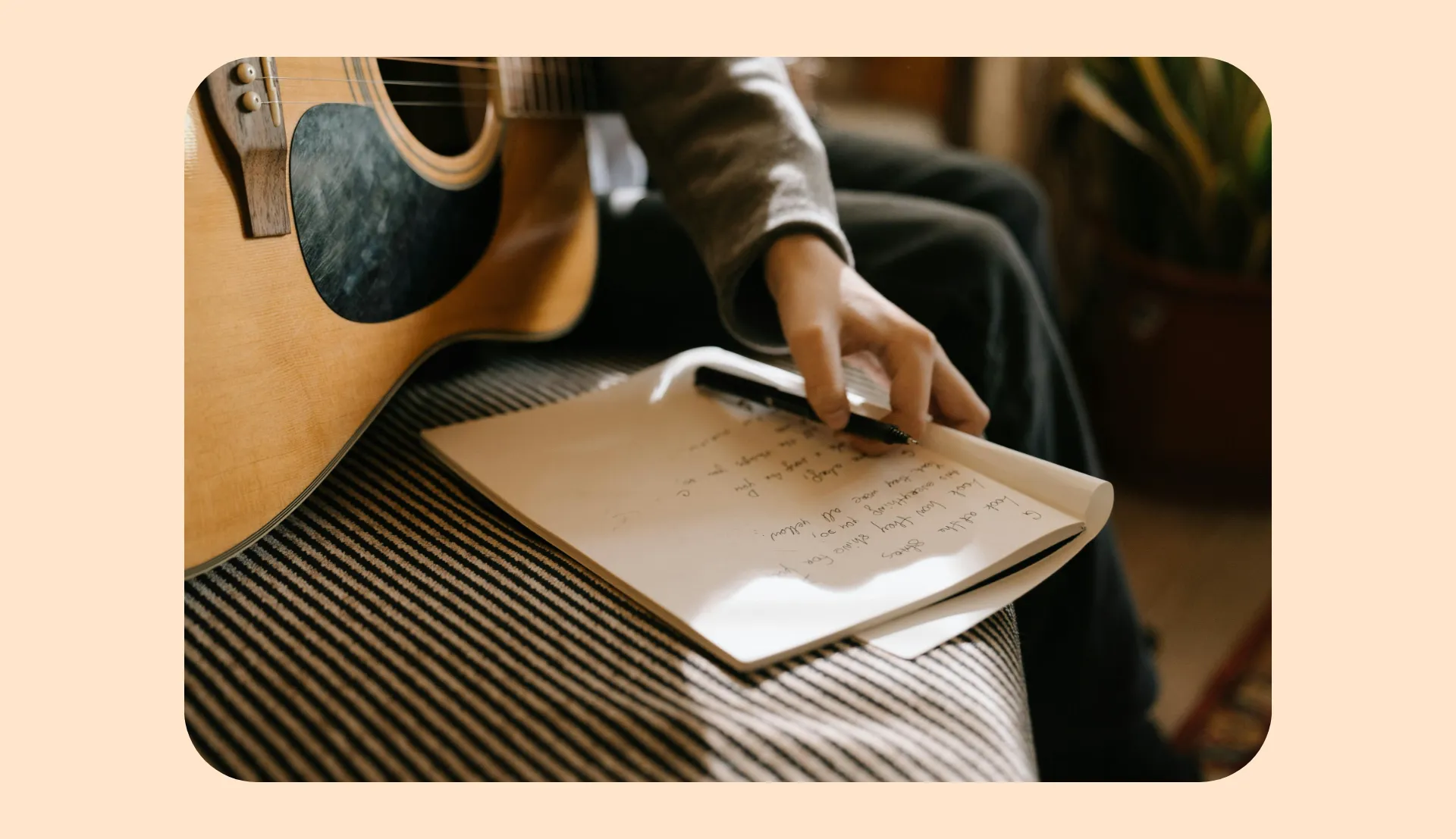 singer writing lyrics with guitar